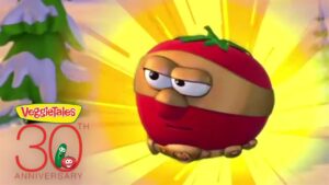 Animated tomato character from VeggieTales is flying with a bright yellow burst background, celebrating the 30th anniversary logo.