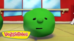 Green round VeggieTales character with a small nose and straight mouth in a dance studio; VeggieTales logo in the lower-left corner.
