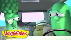 Two VeggieTales characters—a broccoli-headed figure with glasses and a tall green cucumber—sit in a car with a passenger in a hat; logo in corner.