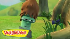 Animated green VeggieTales character with brown hair smiles near a tree in a sunny grassy field; VeggieTales logo in corner.