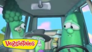 Inside a car, two animated green vegetables from VeggieTales—one on the left wears glasses, the driver on the right, with the VeggieTales logo in the corner.