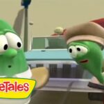Two VeggieTales vegetables talk to each other in a kitchen, with a blender behind them and a hand holding a spatula nearby.