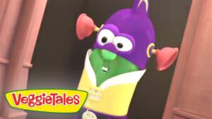 Purple VeggieTales character with a green face and yellow outfit, arms raised in a doorway, logo visible in corner.