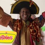 Smiling performer in a colorful pirate-like costume raises arms, VeggieTales logo visible in the corner.
