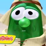 Green VeggieTales character with surprised expression in a desert scene, VeggieTales logo bottom left.