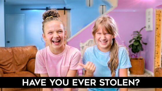 Two smiling girls in pink and blue shirts laugh in a bright, pastel-colored room; bold caption at the bottom asks 'HAVE YOU EVER STOLEN?'.,