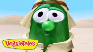 Larry the cucumber from VeggieTales wearing a beige tunic in a desert, with the VeggieTales logo in the lower-left corner.