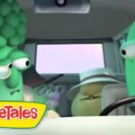 Two VeggieTales characters—a broccoli driver and a cucumber passenger—are riding in a car, with the VeggieTales logo visible in the lower left corner.