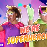 Two people in bright superhero costumes (masks, capes) cheer against a purple confetti backdrop; bold text reads "WE'RE SUPERHEROES!" with a purple "FULL EPISODE" stripe and an "Exclusive" banner.