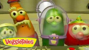 Three VeggieTales characters with large, googly eyes stand together; a green cucumber in a purple space helmet is centered, with a yellow VeggieTales logo in the bottom left.