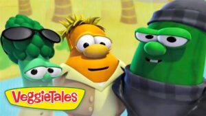 Three VeggieTales characters pose together, a carrot center, a sunglasses-wearing broccoli left, and a green cucumber in a hat and scarf on the right, with VeggieTales logo visible.