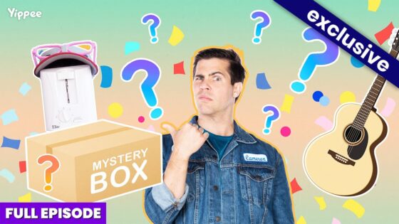Thumbnail for a mystery box video: man in a denim jacket beside a large 'MYSTERY BOX' with a toaster, guitar, and colorful confetti in the background, 'Exclusive' banner visible.