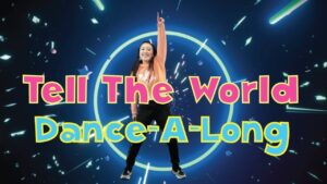 Intro slide for a dance-along video featuring a girl dancing in front of a neon ring and bold pink and blue text: 'Tell The World Dance-A-Long'.