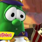 Larry the cucumber from VeggieTales in a captain outfit, looking at a striped popcorn box in a desert landscape.