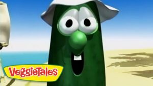 Animated green bean character with a big nose and hat on a sunny beach, VeggieTales logo in the bottom-left.