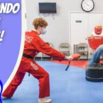 Thumbnail for Taekwondo for Kids: cartoon cowboy on the left; on the right, a red‑uniform instructor holds a kicking pad while a cowboy‑hatted man performs a kick in a dojo setting.