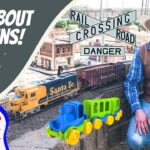 Thumbnail showing a smiling man in a cowboy hat beside a model train layout with bold 'All About Trains!' text and a 'Cowboy Jack' logo cartoon on the left.