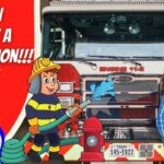 Cowboy Jack standing beside a red fire engine inside a fire station, with bold 'Learn About a Fire Station' text on a red panel and cartoon firefighter character nearby.