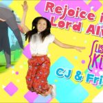 Young girl jumping with a large cartoon elephant and colorful background, title says 'Rejoice in the Lord Always' (kids' video thumbnail).