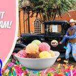Promotional image: pink banner reading 'All About Ice Cream!', a vintage truck, a bowl of colorful ice cream scoops, and a cowboy mascot.