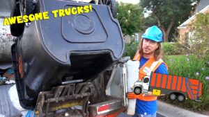 Worker in blue hard hat and orange vest near an overturned dumpster on a truck, with a cartoon truck graphic nearby and bold 'AWESOME TRUCKS!' text overlay.