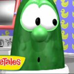 Green veggie character in a bathroom set from VeggieTales, with yellow duck wallpaper and a sink, logo in the corner.