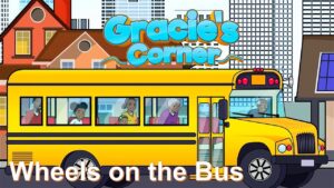 Illustrated yellow school bus with children looking out the windows in a city setting; 'Gracie's Corner' title above and 'Wheels on the Bus' caption.
