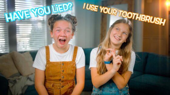 Two smiling girls sitting on a couch, one in tan overalls and the other in denim, with bold captions: 'Have you lied?' and 'I use your toothbrush'.