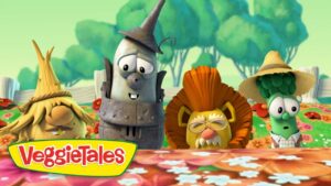 Three VeggieTales characters lean over a flowered table with the VeggieTales logo in the foreground.
