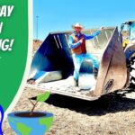 Thumbnail showing a cowboy mascot and bold 'Earth Day Green Recycling' text beside a large yellow front-end loader on a dirt site, with earth-friendly icons nearby.