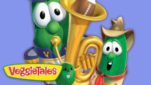 Two VeggieTales characters pose with a large golden brass instrument and the VeggieTales logo visible in bright colors.