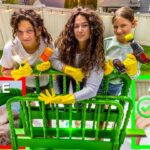 Three girls with yellow gloves pose behind a bright green chair frame, showing a before/after setup with a red X on the left and a green check on the right.