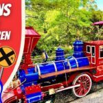 Colorful toy train with a waving cowboy in the cab, beside a 'Trains for Children' banner and 'Cowboy Jack' logo.