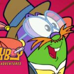 Green cartoon frog, wearing oversized goggles and a brown hat with a blue band, smiling on a pink background with the logo 'LARRYB? The Cartoon Adventures' in the corner.