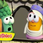 Two VeggieTales characters at a doorway: a green broccoli with wide eyes and a surprised look beside an orange veggie wearing a white headscarf and purple hat, with the VeggieTales logo in the corner.