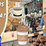 Barista in a cowboy hat and vest carries a tray of iced drinks inside a coffee shop; foreground shows many donuts and playful overlays reading 'What is a Barista?' and 'Cowboy Jack'