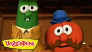 Green cucumber character in a tan plaid suit stands next to a red tomato character with a blue hat and big mustache; VeggieTales logo in the corner.