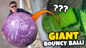 Man in sunglasses grips a massive glittery purple ball at the top of a track, hinting at a giant bouncy ball stunt thumbnail.