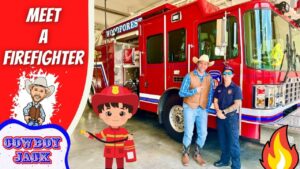 Event at a fire station: a red fire truck with two people posing beside a cartoon cowboy and firefighter stickers in the foreground.