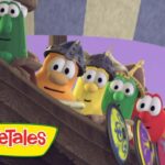 VeggieTales characters lean over the wooden ship railing, ready for adventure.