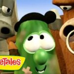 Close-up of three animated VeggieTales characters smiling, with a green vegetable in the center and the logo in the bottom-left corner.