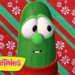 Green VeggieTales character (Bob the Tomato) wearing a red sweater, against a red and teal striped holiday backdrop with snowflakes, VeggieTales logo visible.
