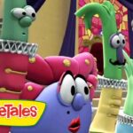 Colorful VeggieTales characters in white ruffled collars gathered in a church-like room with a stained-glass window in the background.