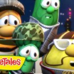 Group of VeggieTales vegetables posed together on a rooftop at night, with a 'FRAGILE' box nearby and city lights in the background.