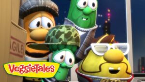 Group of VeggieTales vegetables posed together on a rooftop at night, with a 'FRAGILE' box nearby and city lights in the background.