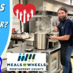 Two volunteers in a kitchen stand by a steaming large pot, promoting volunteers for Meals on Wheels Montgomery County (thumbnail text: 'What is a Volunteer?').**Let’s adjust to ensure clarity**