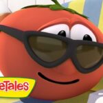 Smiling red tomato from VeggieTales wearing sunglasses and relaxing on a striped pool chair, with a life preserver in the background and VeggieTales logo nearby.