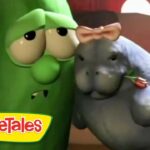 Larry the Cucumber and a gray hippo from VeggieTales share a friendly hug, with the VeggieTales logo in the bottom-left corner.