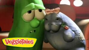 Larry the Cucumber and a gray hippo from VeggieTales share a friendly hug, with the VeggieTales logo in the bottom-left corner.