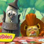 Animated VeggieTales characters stand behind a flower-filled table in a sunny garden; colorful logo in front.